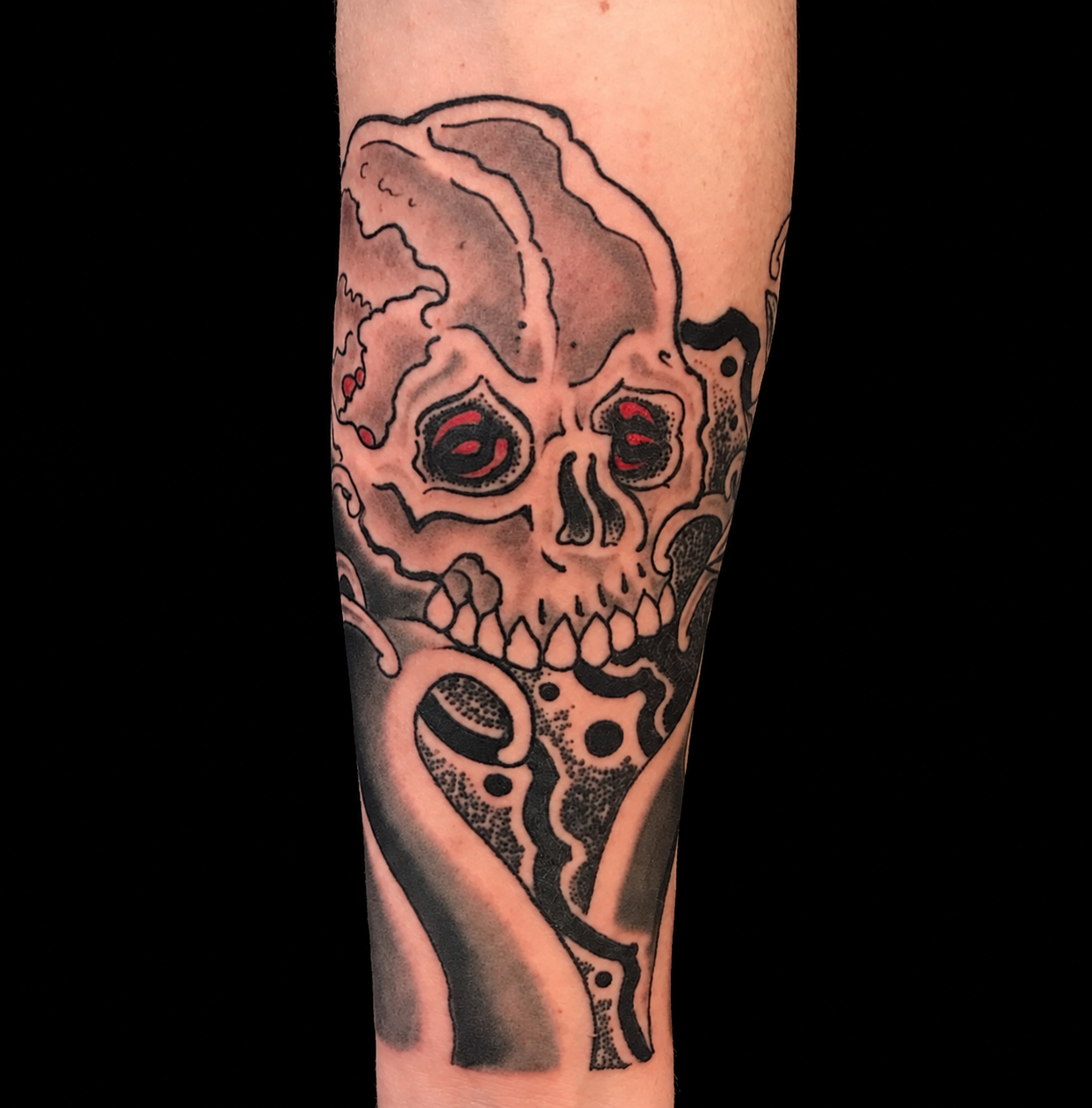 Skull forearm tattoo on a solid black background