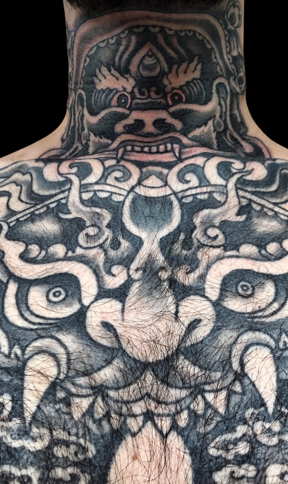 Black and grey Japanese neck and back tattoo displayed on a black gallery background