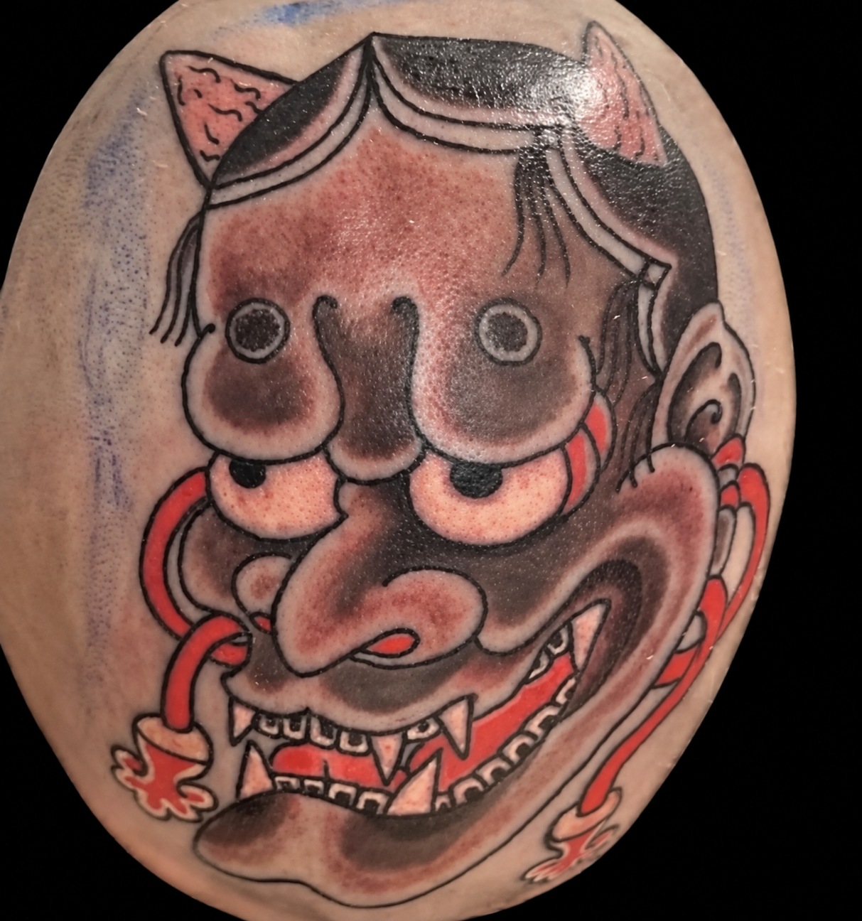 Small black and red Tengu mask tattoo
