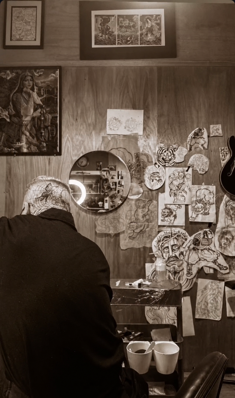Roddy working in the tattoo studio surrounded by Japanese tattoo artwork