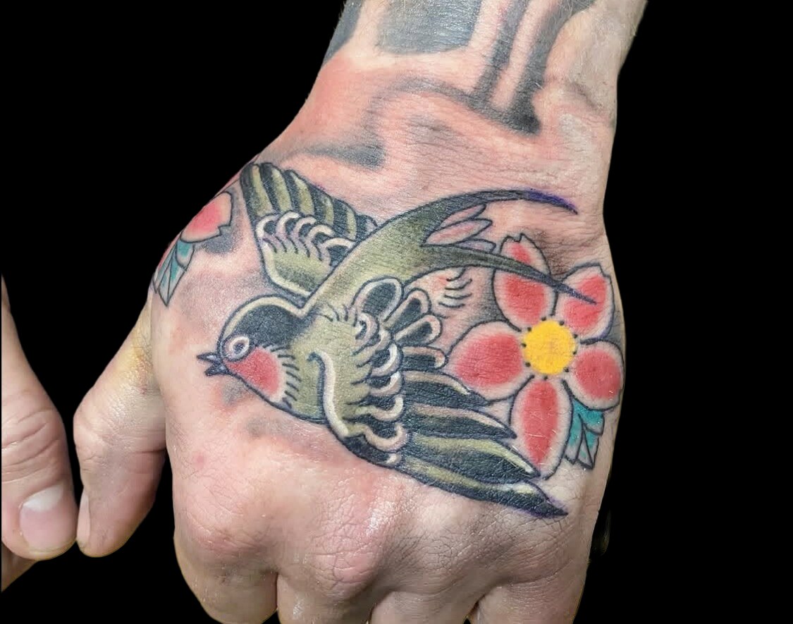 Swallow and cherry blossom hand tattoo